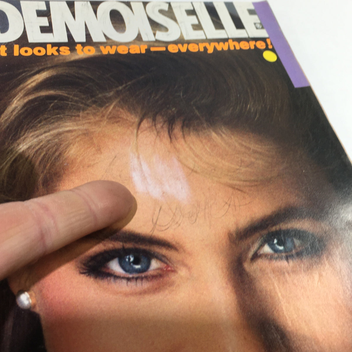 Detailed view of VTG Mademoiselle Magazine April 1982 cover, showcasing the model's blue eyes and hair, alongside headlines related to beauty and fashion.