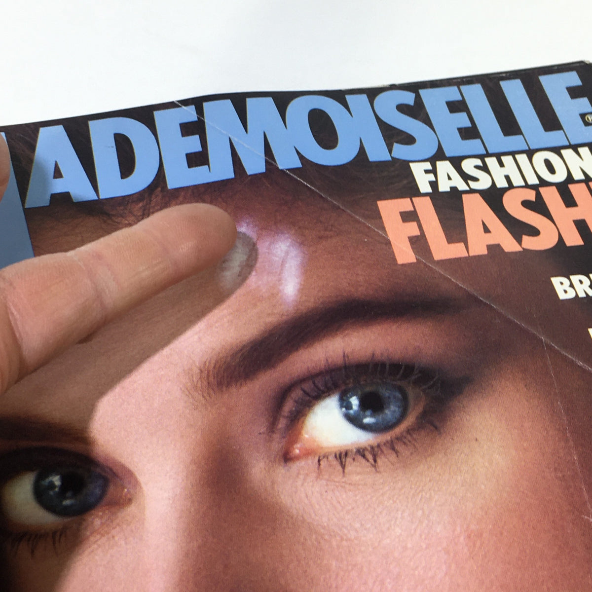 Close-up of the cover of VTG Mademoiselle Magazine April 1983, focusing on the model's face, emphasizing her blue eyes and stylish makeup, part of the iconic issue by Jenny Howorth.