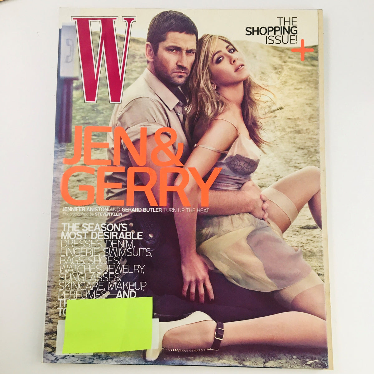 W Magazine April 2010 cover featuring Jennifer Aniston and Gerard Butler, highlighting their film Friends with Benefits. The cover showcases vibrant visuals and the theme of the issue, which is The Shopping Issue.