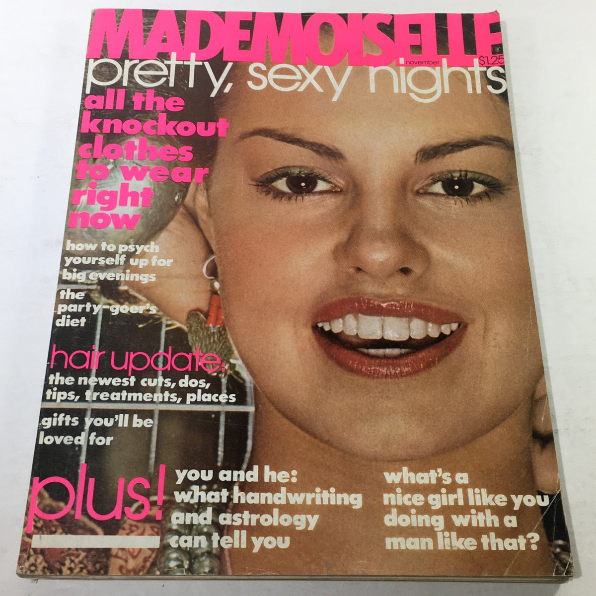 Cover of VTG Mademoiselle Magazine: November 1976 featuring vibrant pink text and a smiling model showcasing vintage fashion trends, emphasizing 1970s style.