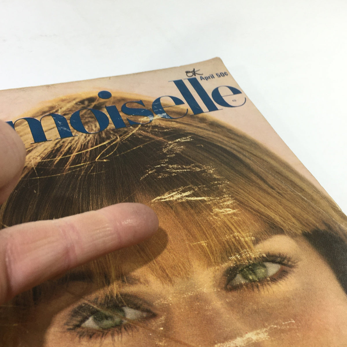 Close-up of the VTG Mademoiselle Magazine: April 1967 cover, highlighting the model's eyes and hair against a vintage design.