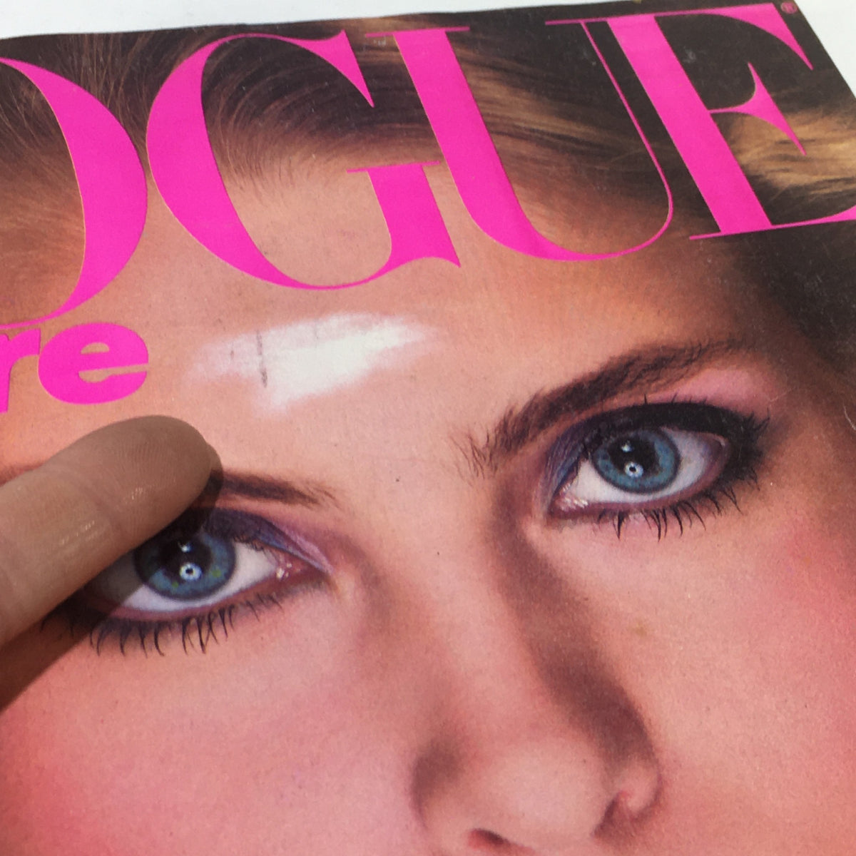 Detailed close-up of VTG Vogue Magazine: November 1980 cover, focusing on Kim Alexis's striking features and makeup, capturing 1980s fashion.