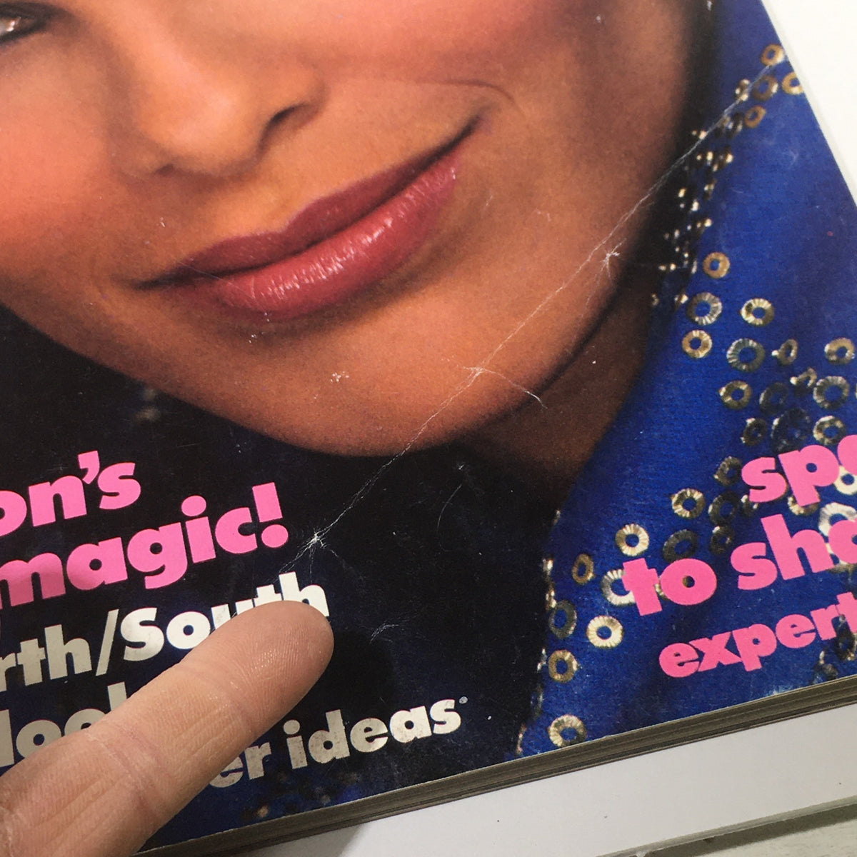 Close-up detail of the VTG Vogue Magazine: December 1982 cover, highlighting minor imperfections and text elements promoting seasonal fashion ideas.