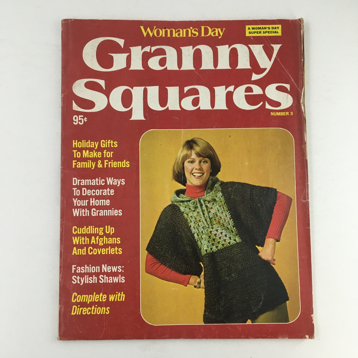 Cover of Woman's Day Magazine #3 from 1975, featuring the title 'Granny Squares' with a woman wearing a knitted poncho. The cover highlights content on holiday gifts, decorating tips, and includes a section on 'Cuddling Up with Afghans and Coverlets'.