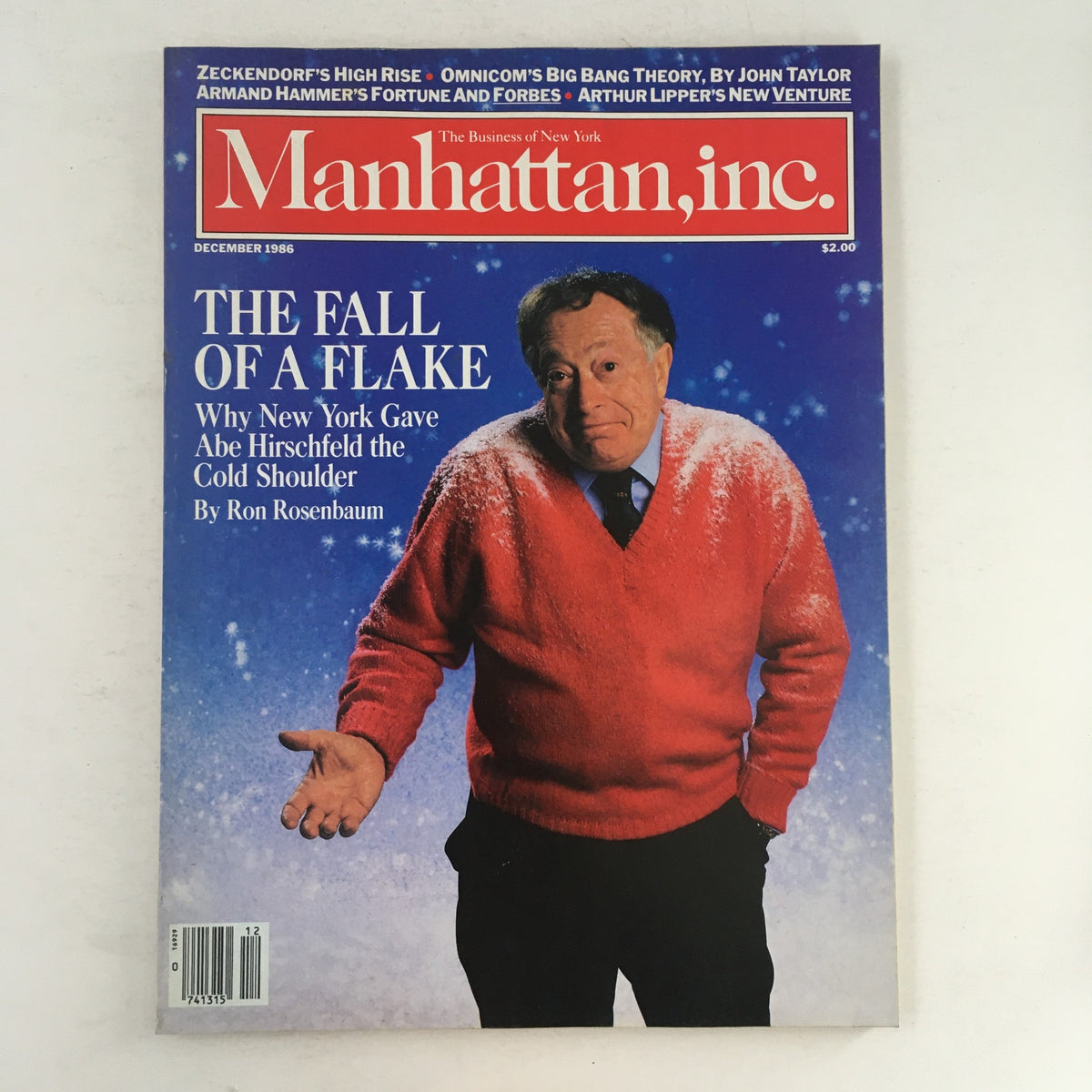 Manhattan Inc. Magazine December 1986 cover featuring the article 'The Fall of a Flake' about Abe Hirschfeld, showcasing a man in a red sweater with a snowy background.