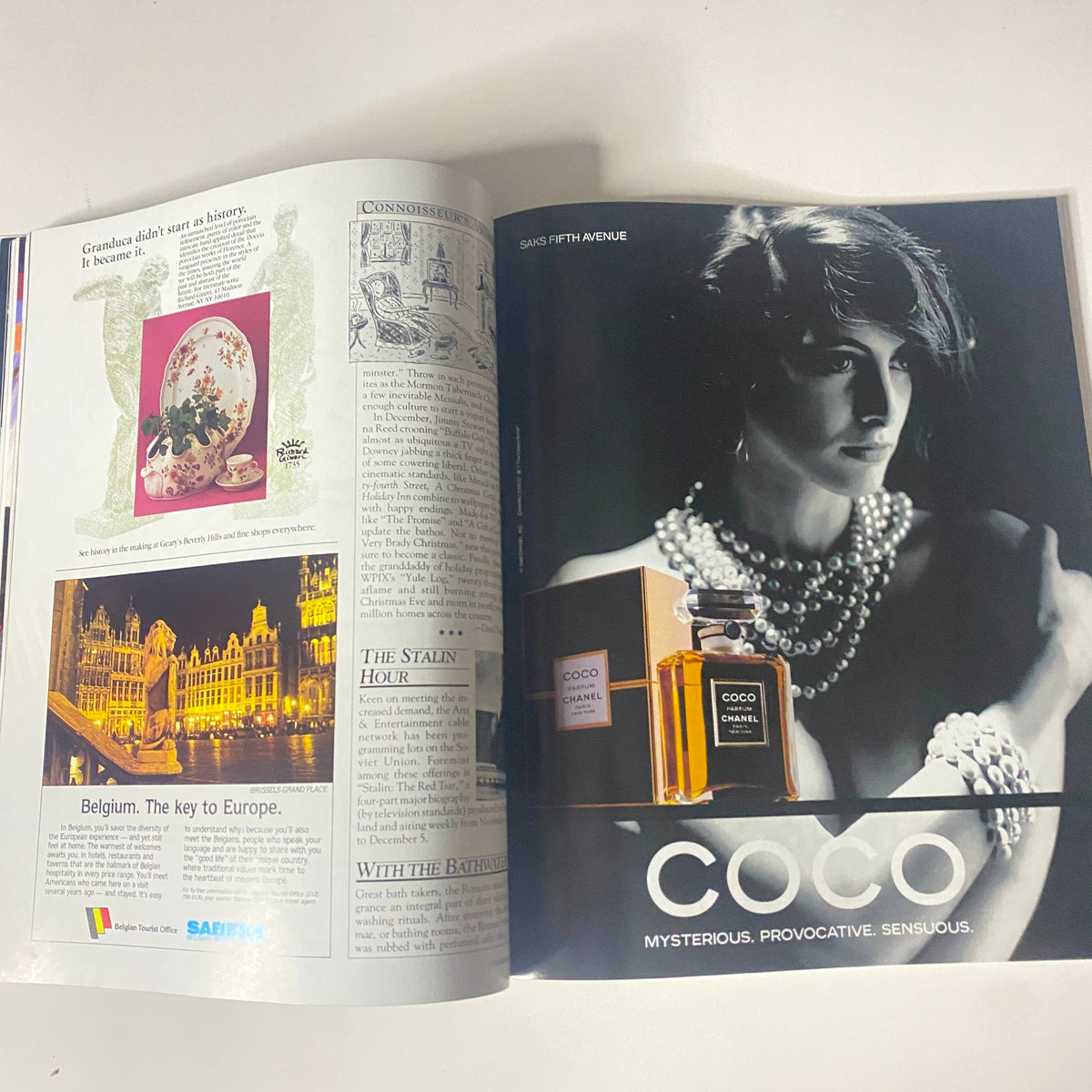 Inside view of Connoisseur Magazine December 1988 featuring an advertisement for Coco Chanel perfume and an article on Belgian heritage. Vintage magazine showcasing 1980s fashion and cultural themes.