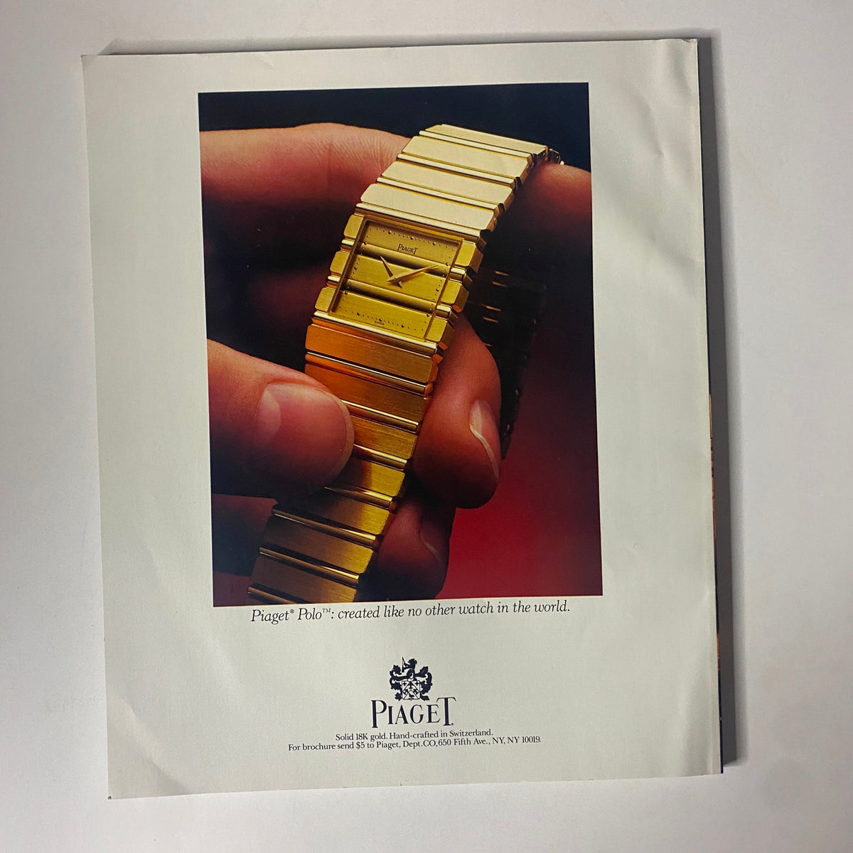 Vintage advertisement for the Piaget Polo watch, featuring a close-up of the luxurious 18k gold timepiece held in a hand. The ad highlights the craftsmanship and elegance of the watch, emphasizing its unique design in connection with the Connoisseur Magazine July 1986 issue titled 'Classic French Door.'