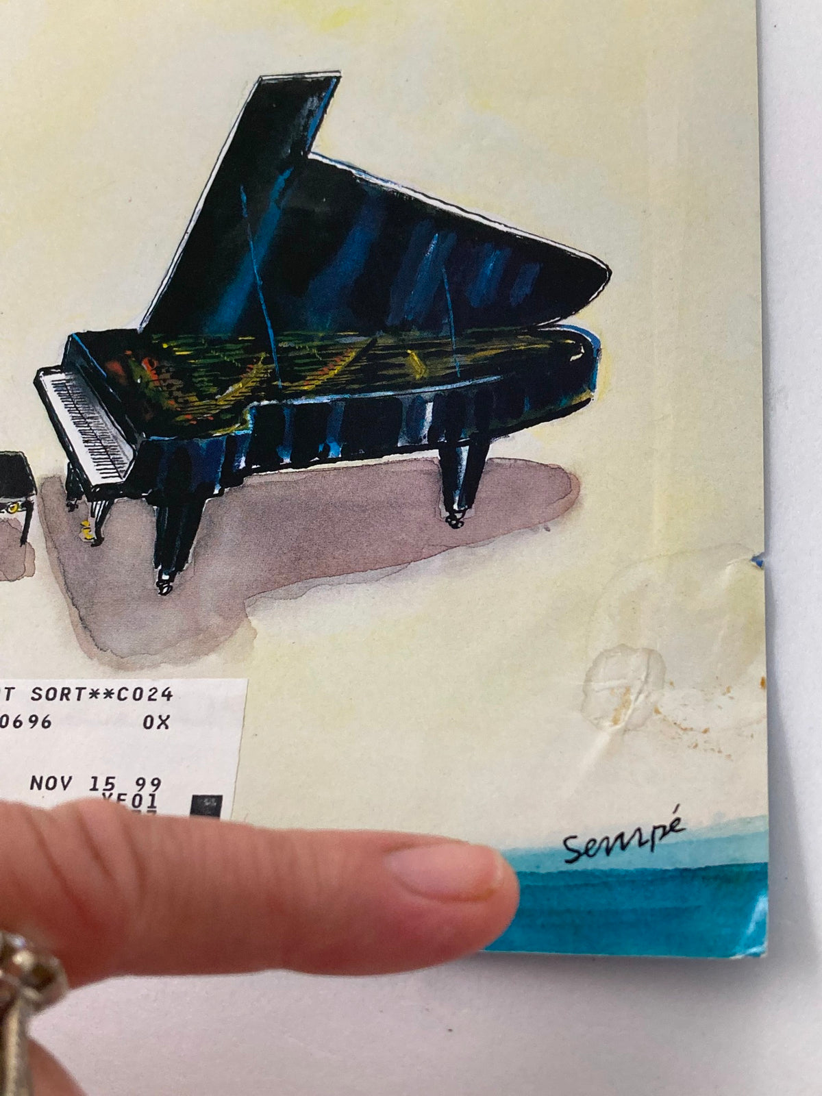 Close-up of the grand piano featured on The New Yorker March 29 1999 cover, titled 'Slight Anxiety' by Jean-Jacques Sempe, highlighting the intricate artwork and artist’s signature.