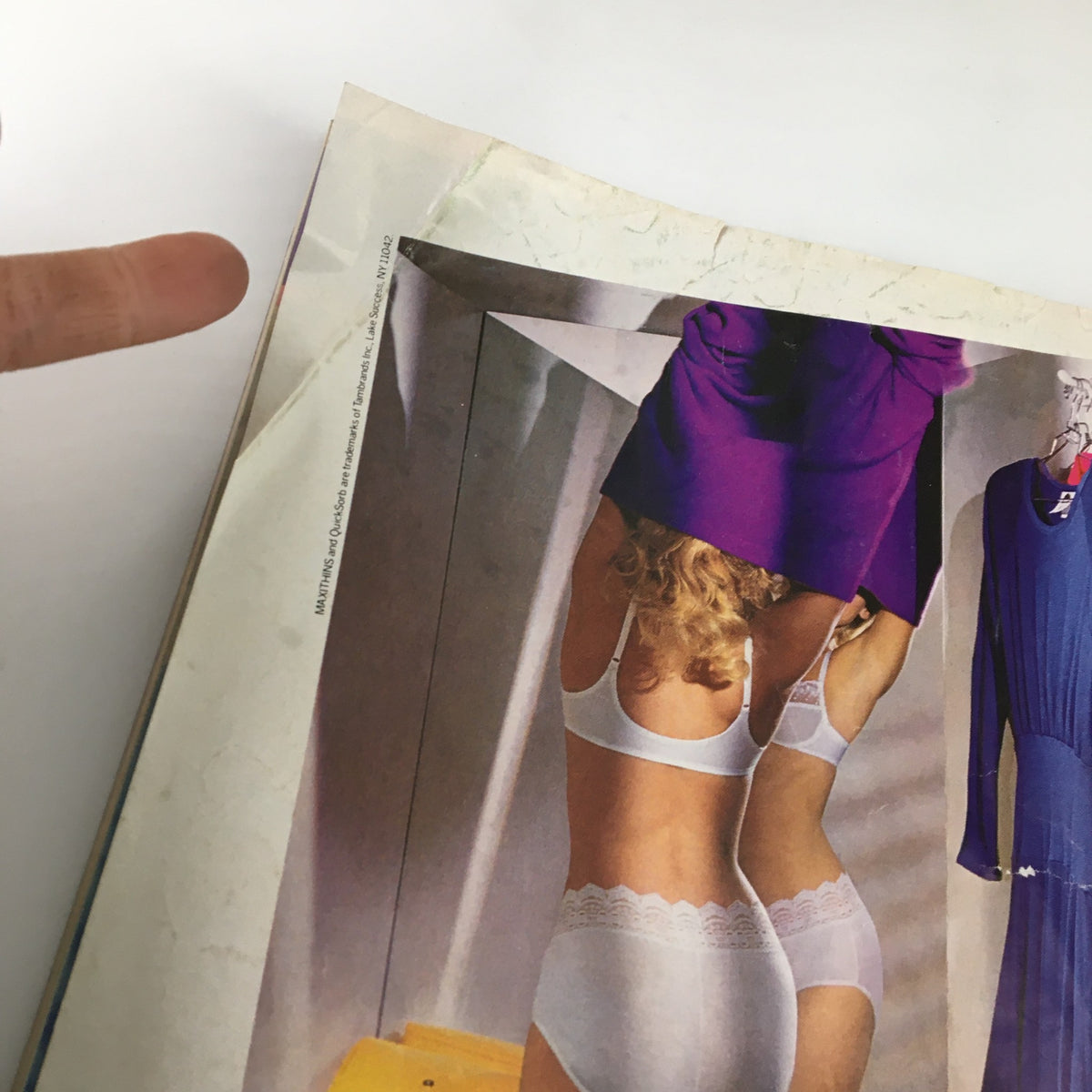 Close-up view of a page from the VTG Teen Magazine June 1987 featuring a vintage fashion ad with two women trying on clothing, showcasing 80s style. This collectible magazine includes popular 80s figures like the Brat Pack and Michael J. Fox.
