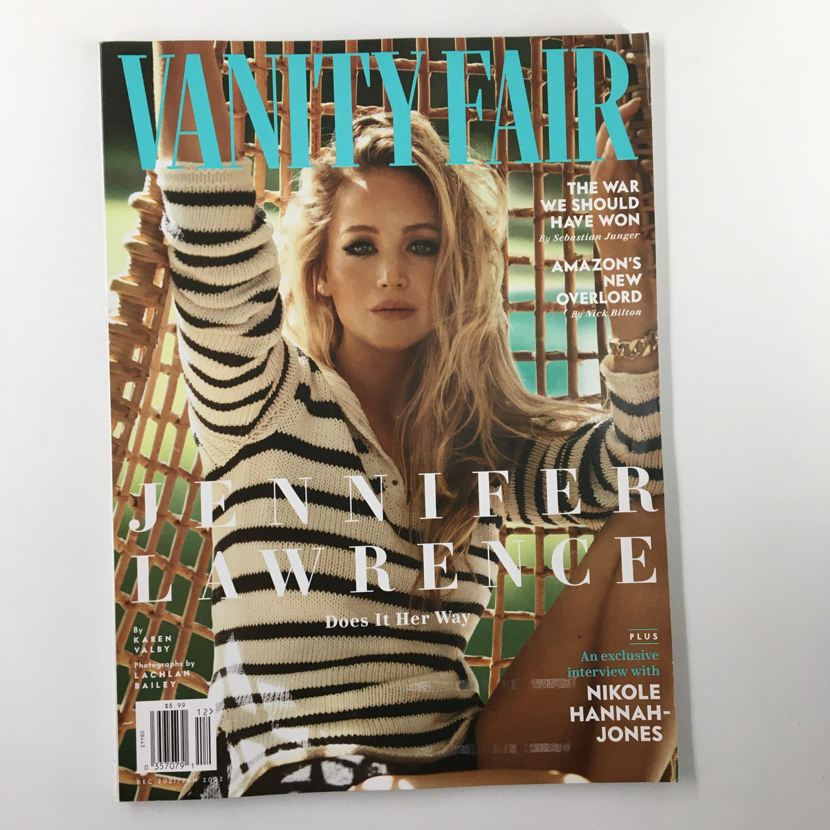 Cover of Vanity Fair Magazine December 2021 featuring actress Jennifer Lawrence with the title 'Does It Her Way'. The image showcases Jennifer in a striped outfit, seated in a chic setting, reflecting her unique perspective and Hollywood journey.