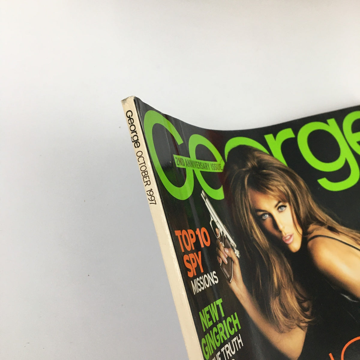 Cover of George Magazine October 1997 featuring Elizabeth Hurley with a gun, highlighting the issue's theme and aesthetic.