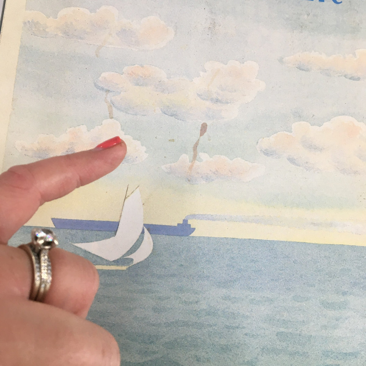 Close-up detail of 'Sail Away' cover from The New Yorker Magazine May 13, 1985, showing clouds and a sailboat with a finger pointing at the illustration.