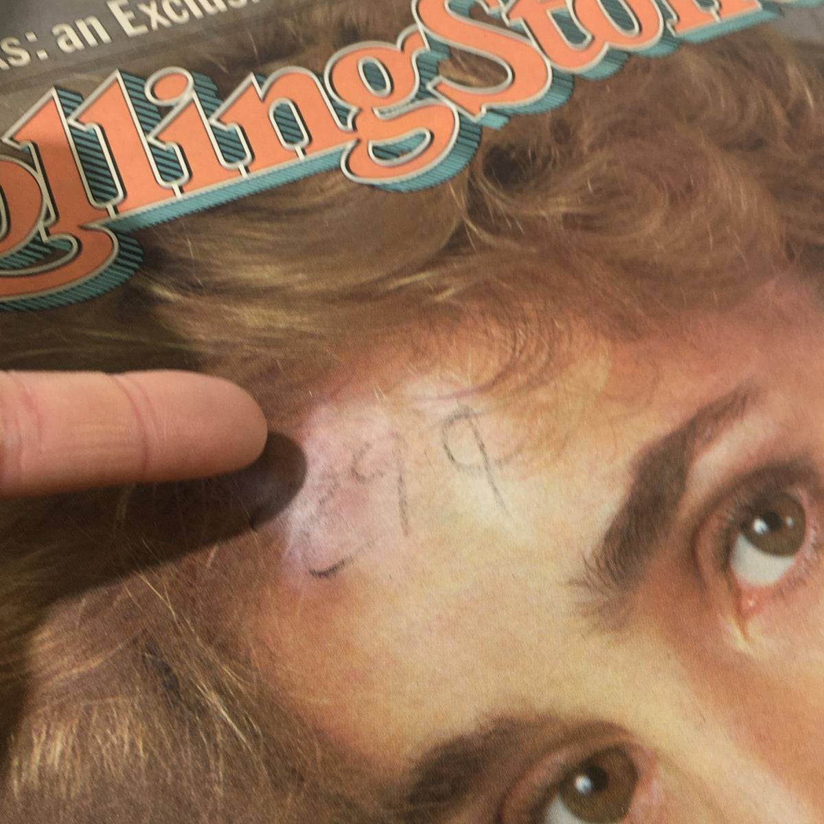 Close-up of the cover of VTG Rolling Stone magazine from March 17, 1983 featuring a mark on the forehead area, with highlighted text referring to Jessica Lange Blonde Obsession.