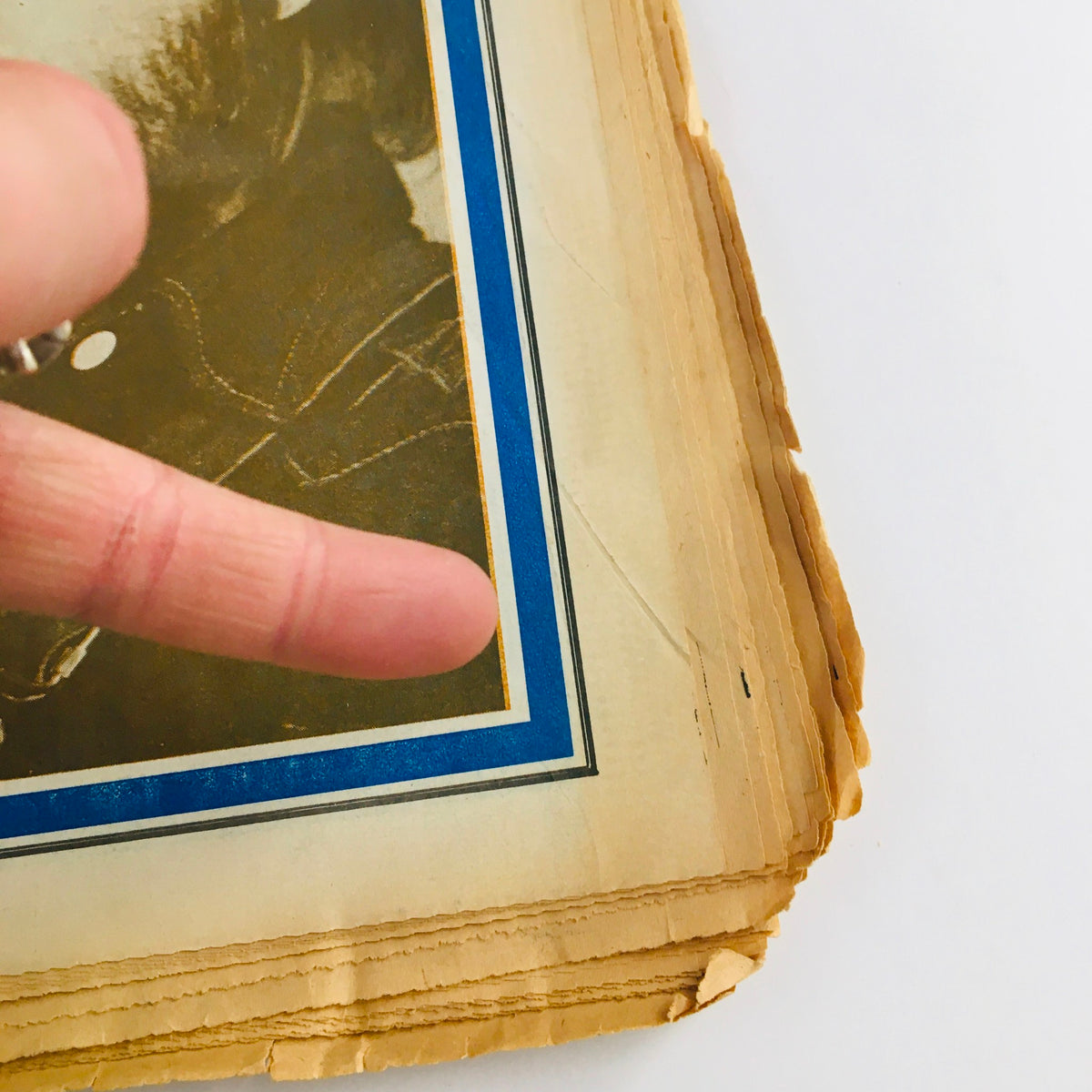 Close-up view of the edge of the Rolling Stone Magazine from January 21, 1971 featuring John Lennon, showcasing its vintage condition with light wear and frayed pages, relevant for collectors and music history enthusiasts.