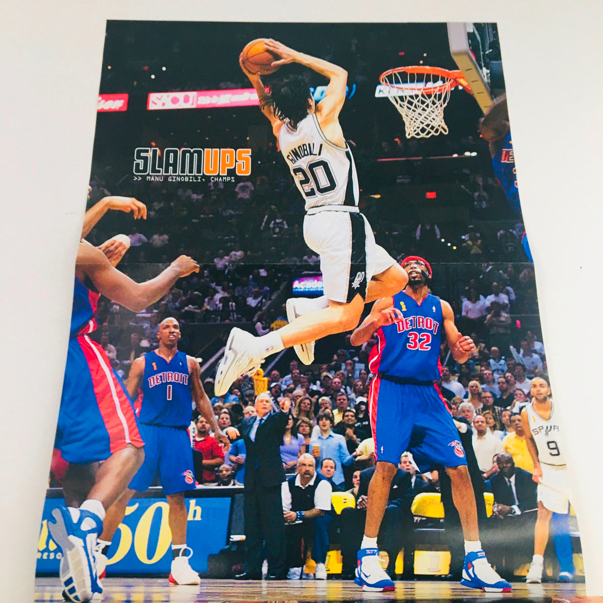 Poster from Slam Magazine September 2005 showcasing Manu Ginóbili in action, jumping for a shot against the Detroit Pistons, part of an iconic basketball collectible.