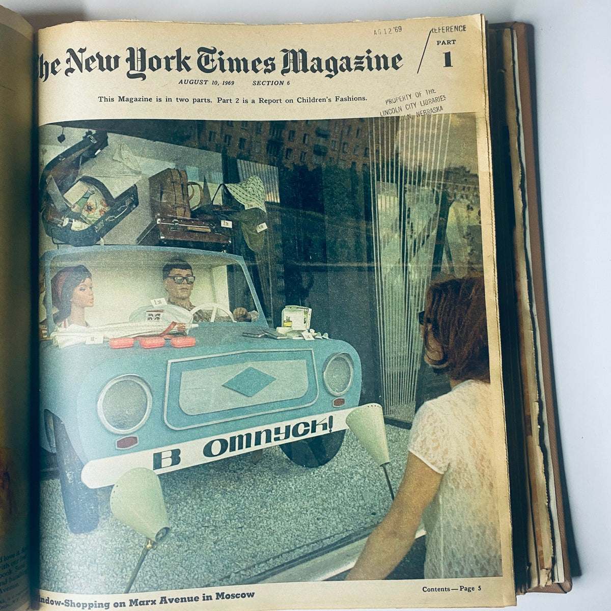 Cover of The New York Times Magazine, August 10, 1969, showcasing a vintage car display with a woman window-shopping, highlighting trends in children's fashion.