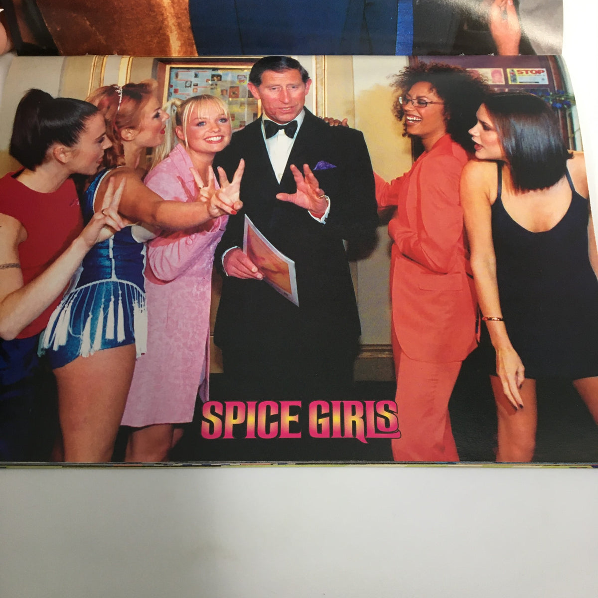 Hit Sensations Magazine 1998 with Spice Girls posing alongside a royal figure, celebrating their iconic status and cultural influence.
