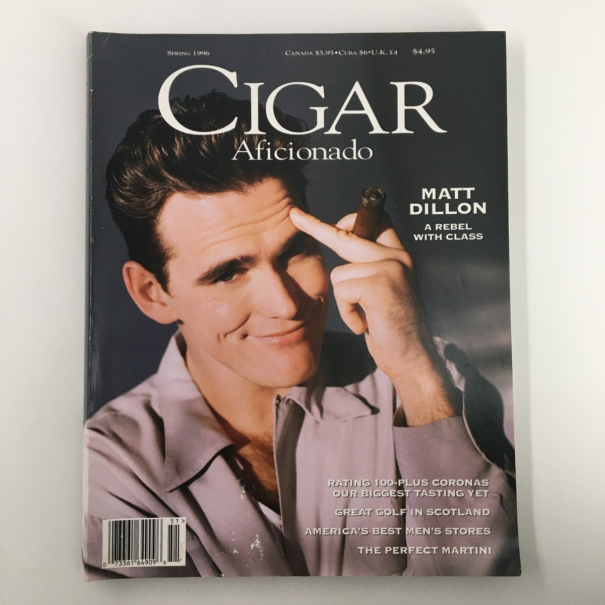 Cigar Aficionado Magazine Spring 1996 featuring Matt Dillon on the cover, labeled ‘A Rebel with Class’, showcasing a vintage aesthetic with a soft smile and cigar in hand.