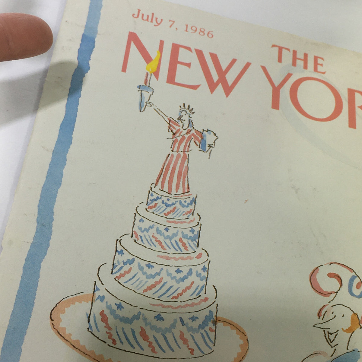 Close-up of the cover of The New Yorker Magazine from July 7, 1986, highlighting the Statue of Liberty on a cake drawn in vibrant colors.