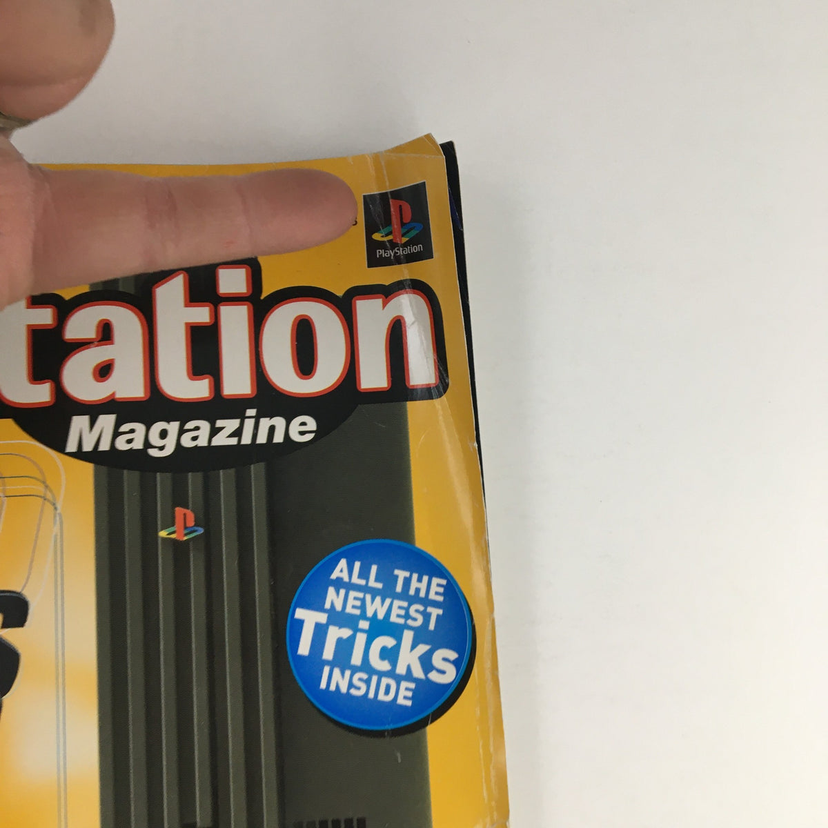 Close-up of the PlayStation Magazine December 1999 cover highlighting the PlayStation logo and promotional section about new tricks in gaming.