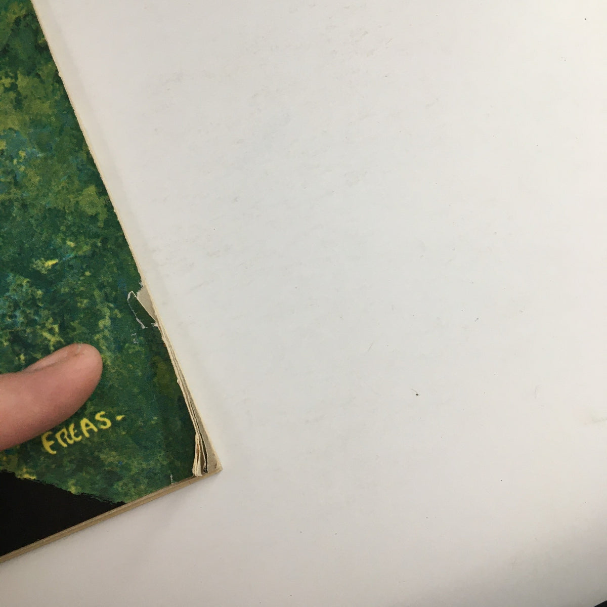 Close-up view of the spine of Mad Magazine March 1962 #69, highlighting the signature of artist Kelly Freas and minor wear on the cover.
