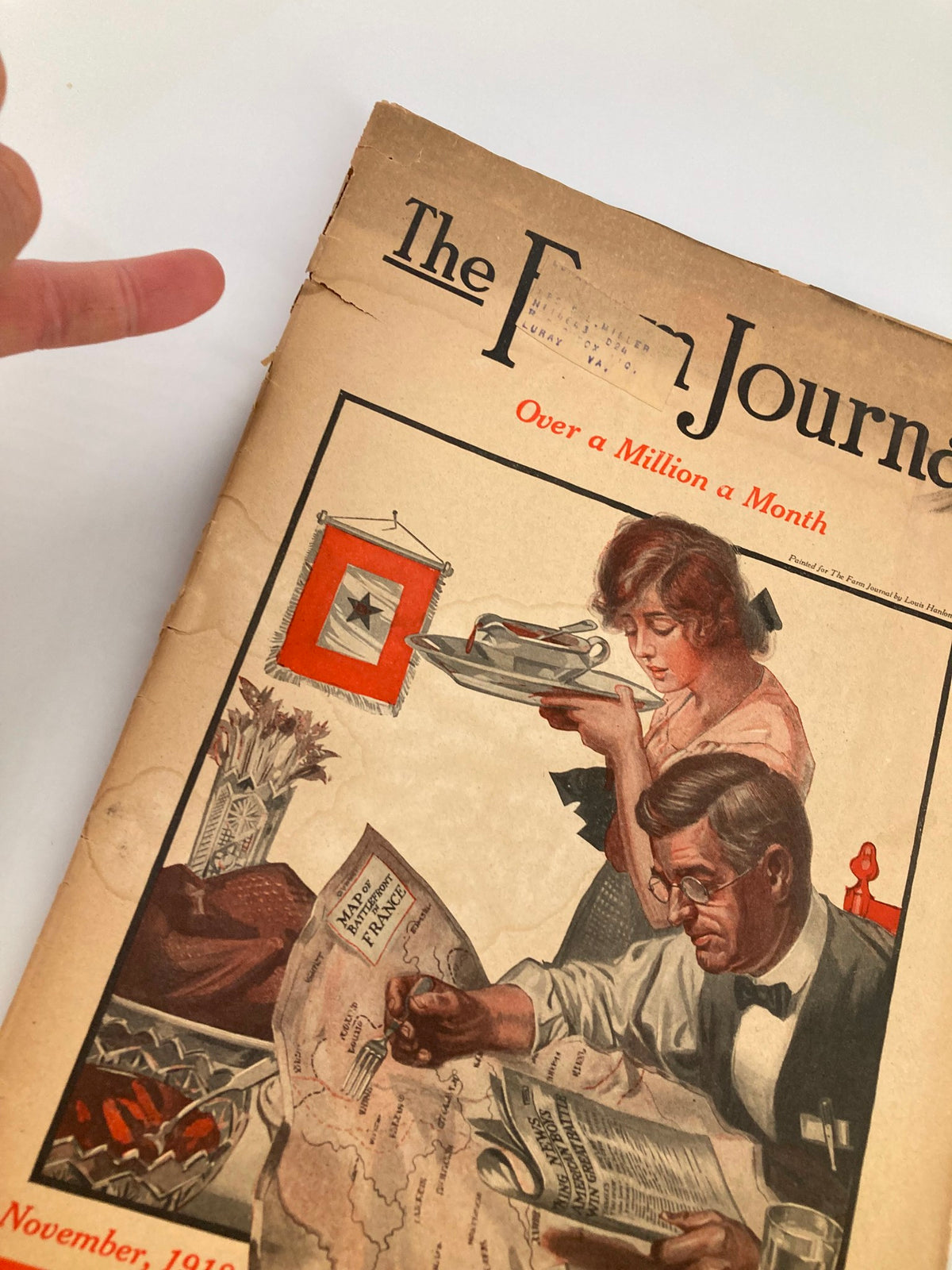 Close-up of the cover of VTG The Farm Journal Magazine November 1918, showing a woman with a platter and a man with a map, emphasizing the magazine's theme of financial strategies in agriculture.