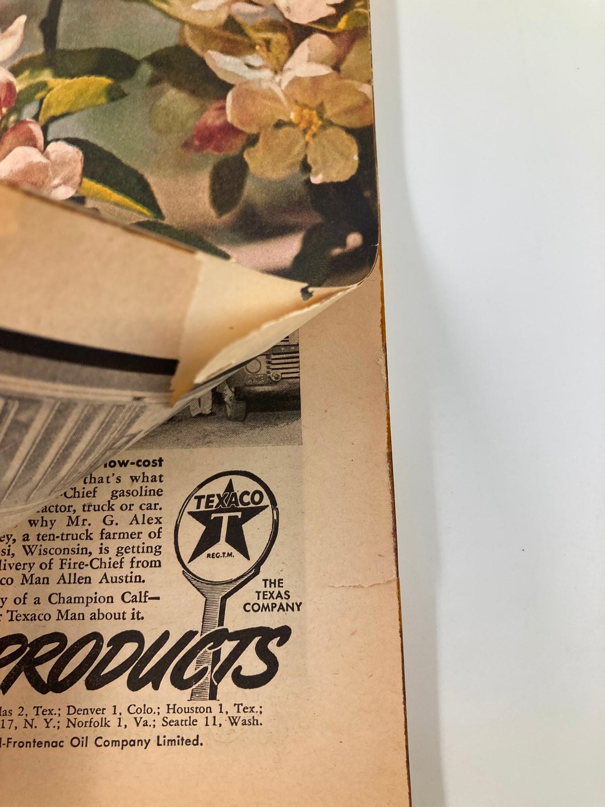 Close-up of a vintage advertisement from VTG Farm Journal Magazine April 1951, featuring Texaco oil products next to floral design.