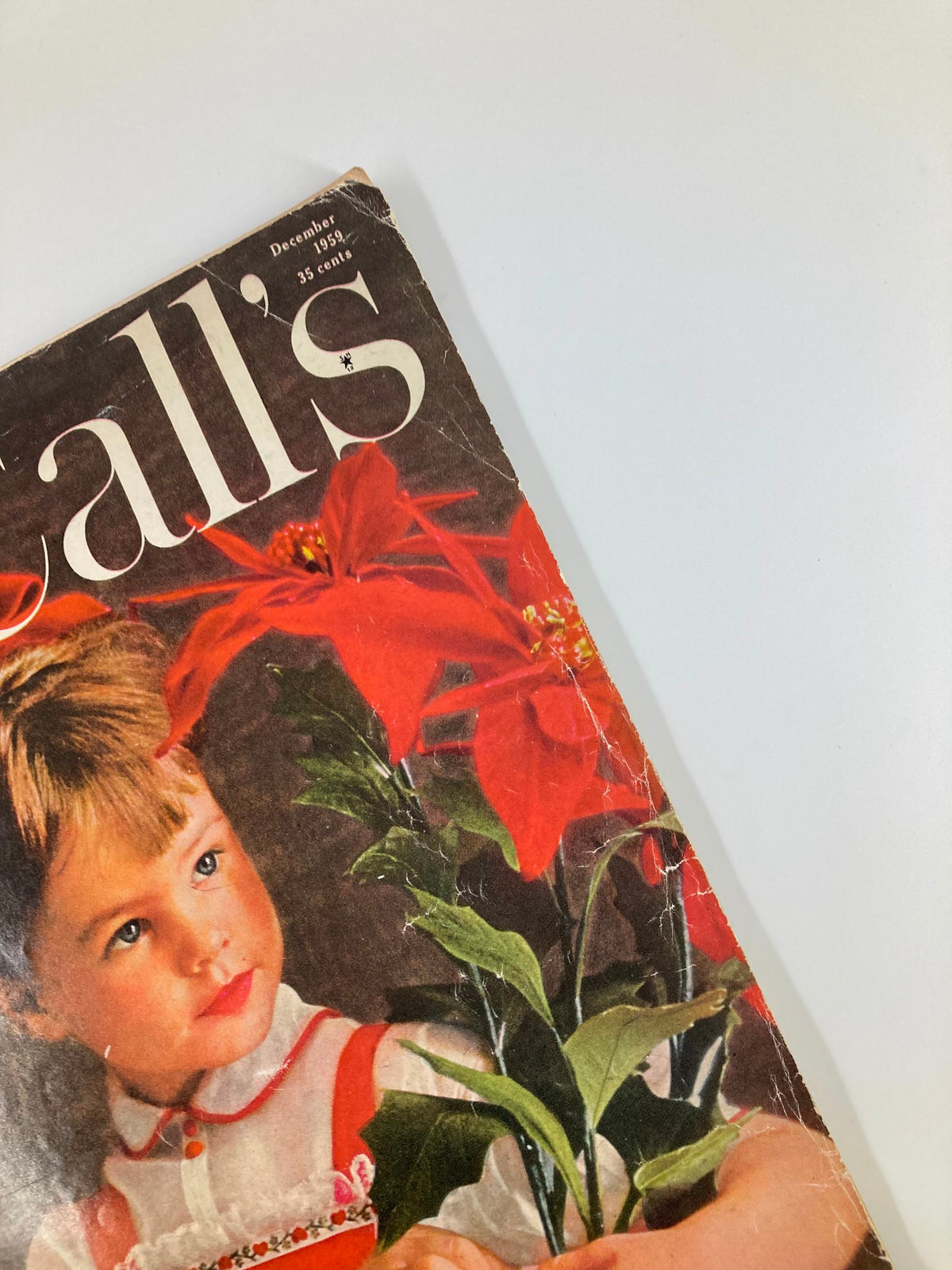 Top angle view of the VTG McCall's Magazine December 1959 Cover, illustrating the festive theme and young girl holding a potted plant.