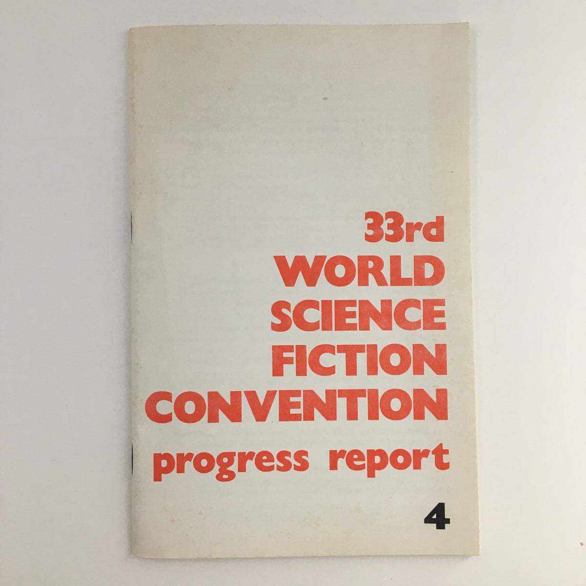 Cover of the 'Aussie Con The 33rd World Sci-Fi Con 1975 Progress Report' featuring bold red typography.