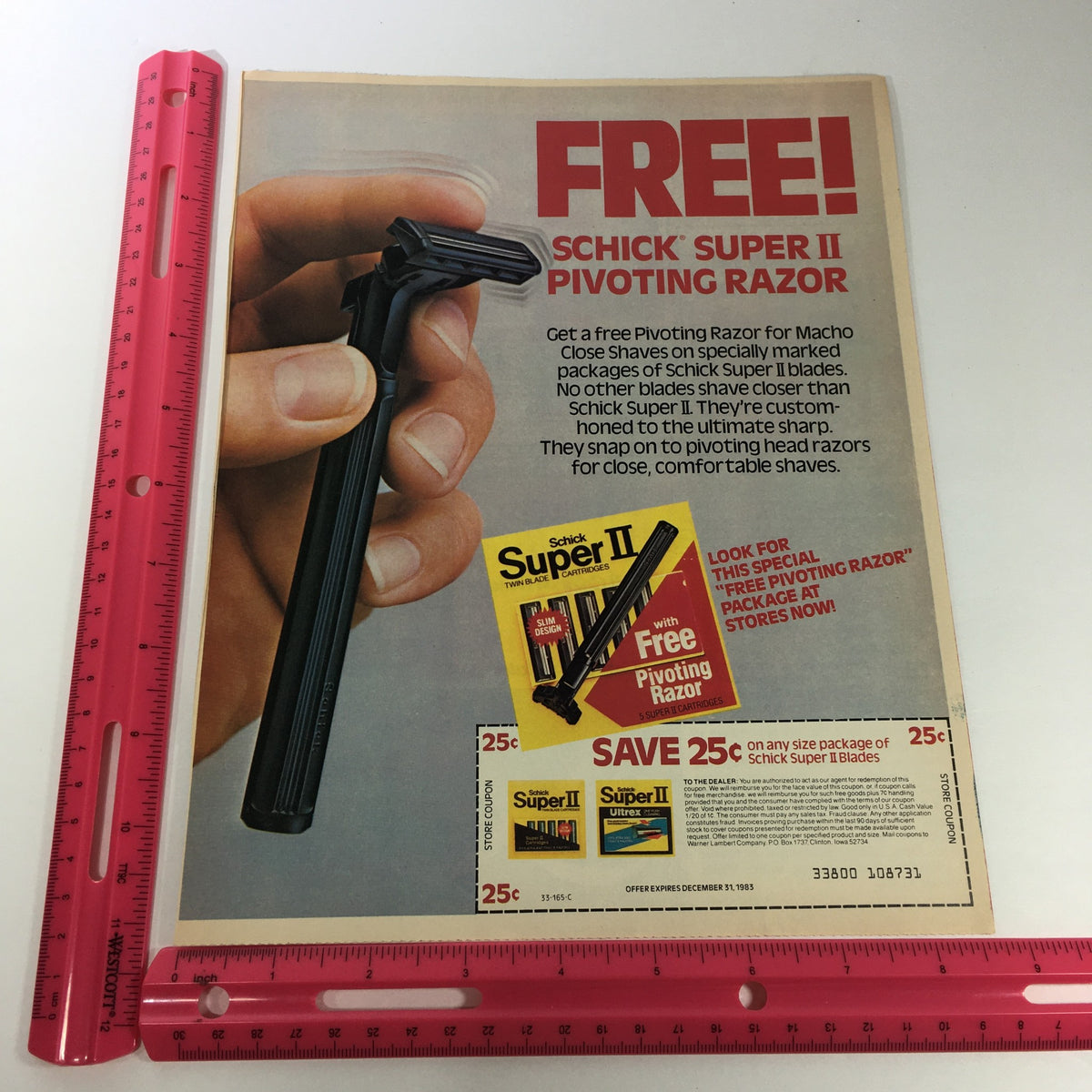 Close-up view of the 1983 Schick Super II Blades advertisement with a ruler for size reference, promoting the FREE Pivoting Razor coupon.