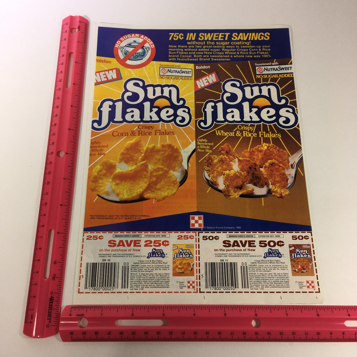 VTG Retro 1986 Nutra Sweet Sun Flakes Crispy Corn, Wheat & Rice Flakes advertisement featuring two product boxes, highlighting savings on each, with a ruler for size reference.