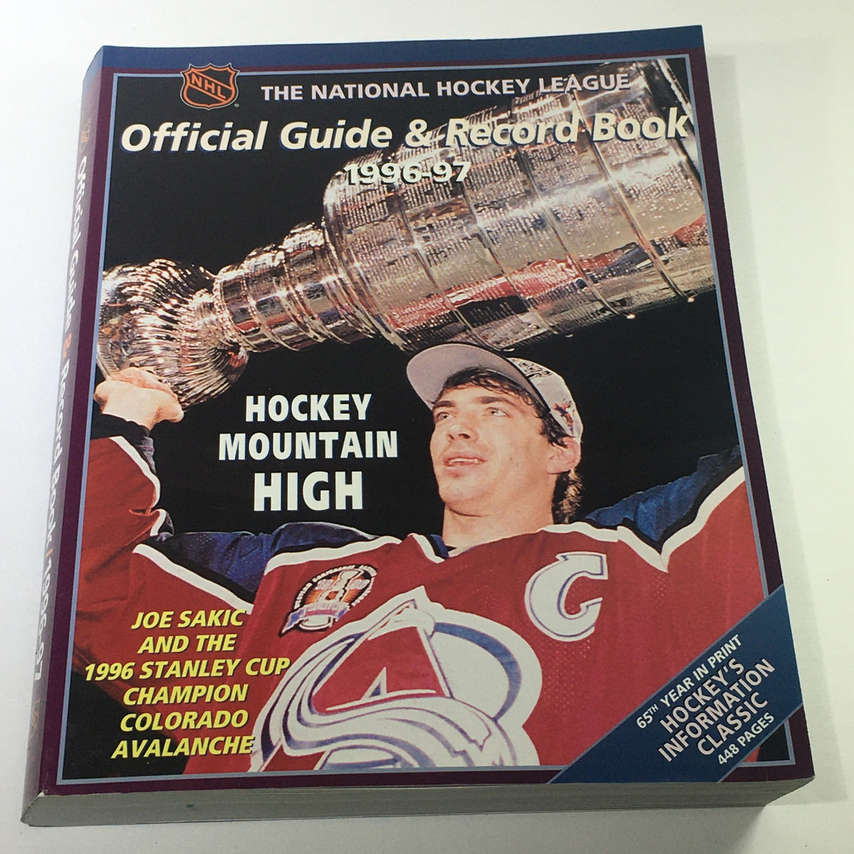 VTG NHL Official Guide & Record Book 1996-1997 featuring Joe Sakic of the Colorado Avalanche holding the Stanley Cup, showcasing hockey memorabilia.