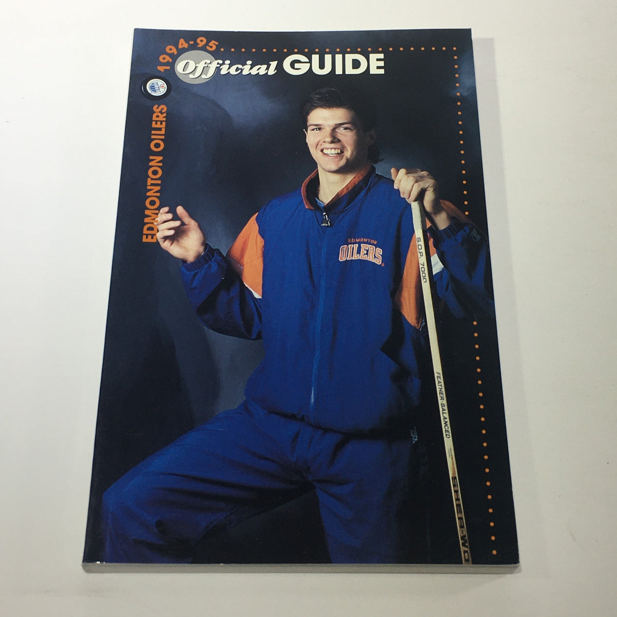 Official guide for the Edmonton Oilers from 1994-95, displaying a player in team attire, highlighting player engagement and team spirit.