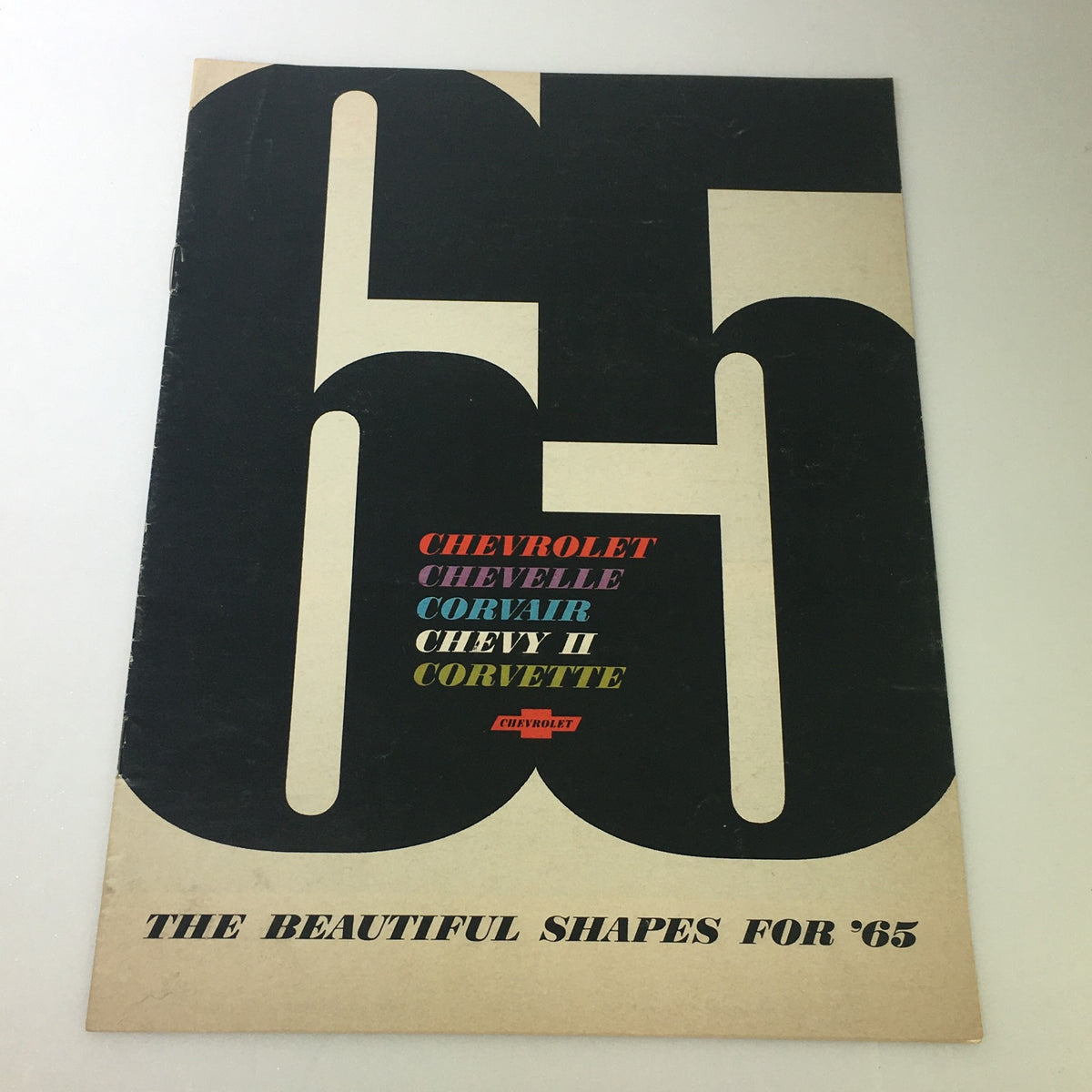Cover of the VTG 1965 Chevrolet Chevelle Corvair Chevy II Corvette Car Auto Brochure Catalog showcasing bold typography and design featuring the slogan 'THE BEAUTIFUL SHAPES FOR 65'.