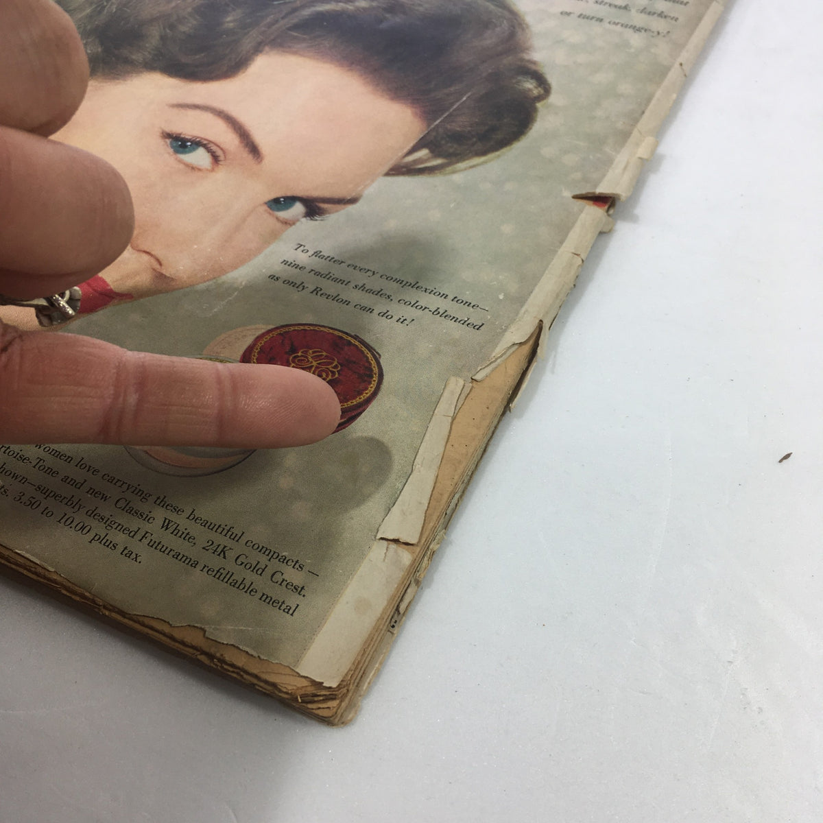 Detail view of the back cover of the VTG Motion Picture Magazine June 1959, showing damages with a focus on a finger pointing at text regarding cosmetics. The magazine features Shirley Boone and Pat Boone.