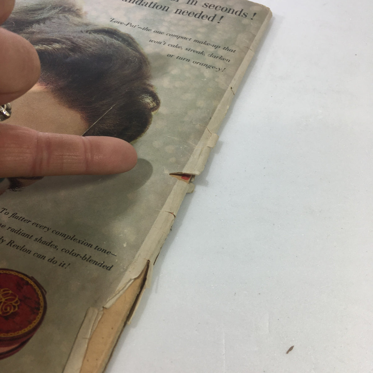 Image showing the back side of the VTG Motion Picture Magazine from June 1959, focusing on notable nearing the spine with a finger pointing at an advertisement. The vintage magazine features Shirley Boone and Pat Boone on the cover.