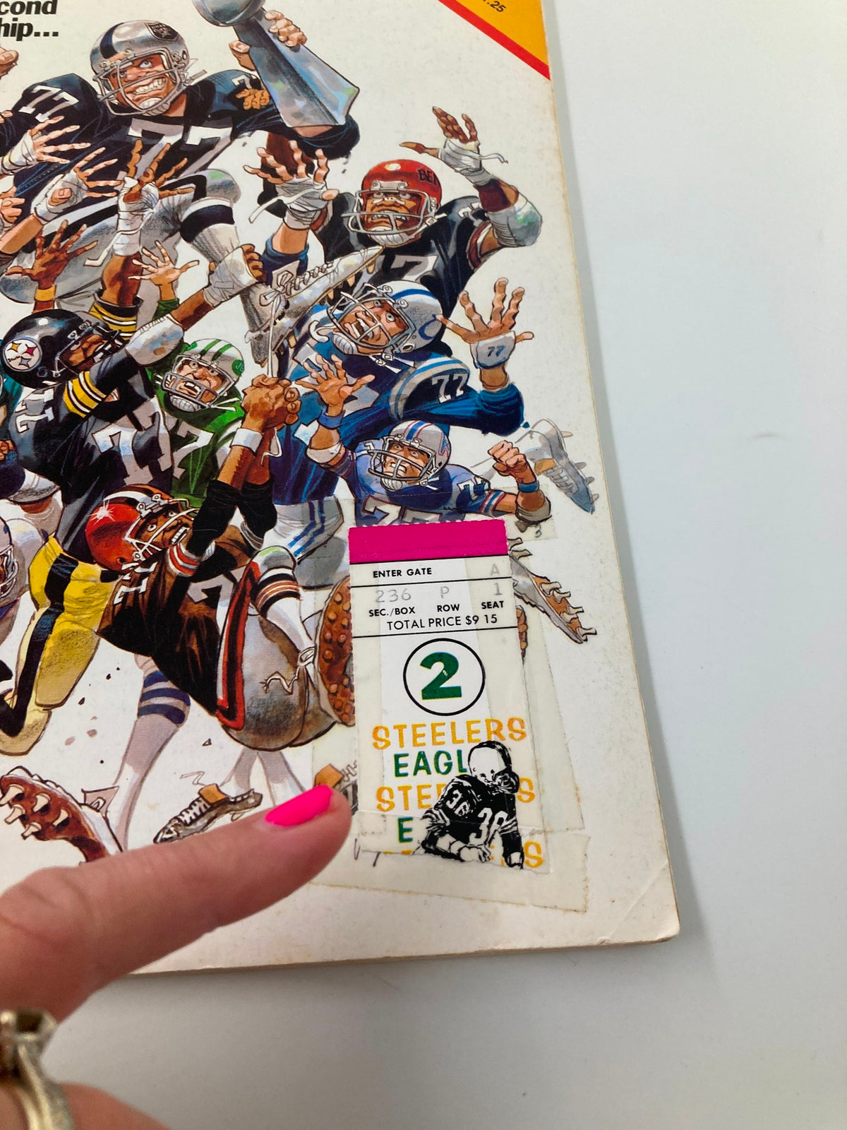 Close-up of the VTG Pro! Official NFL Magazine September 2 1977 showing a ticket stub taped to the cover, emphasizing its collectibility. The magazine features key NFL players in a dynamic illustration, appealing to vintage sports memorabilia enthusiasts.