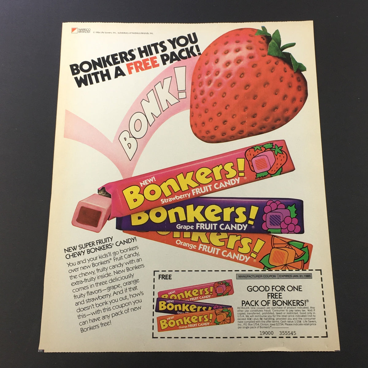 VTG Retro 1985 Bonkers Super Fruity Chewy Candy Print Ad Coupon featuring colorful candy wrappers and a strawberry. The advertisement highlights the flavors strawberry, grape, and orange, promoting a free pack offer.
