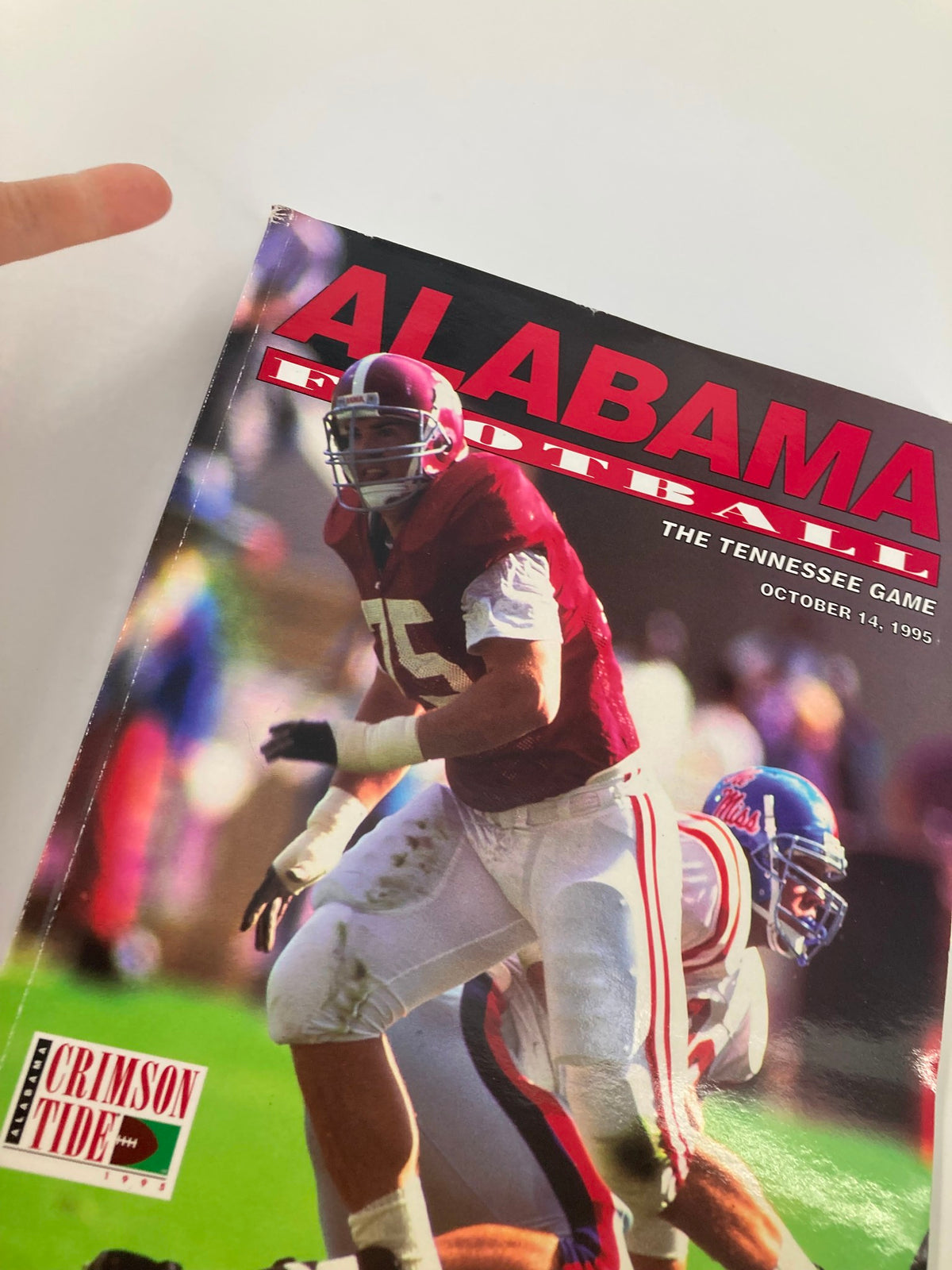 Cover of 'October 14 1995 The Tennessee Game U. of Alabama Official Souvenir Program' featuring a football player in Alabama's crimson jersey during the game.