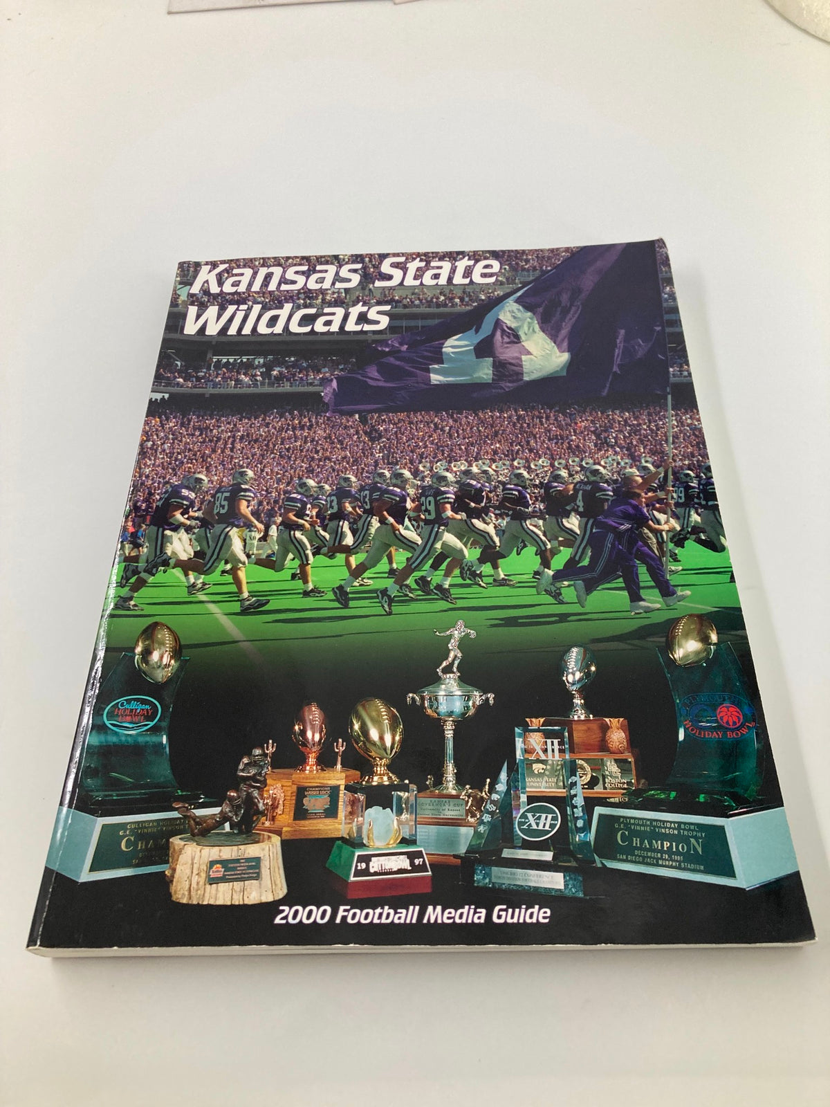 Cover of the 2000 Kansas State Wildcats Football Media Guide showcasing team spirit and notable memorabilia from the season.