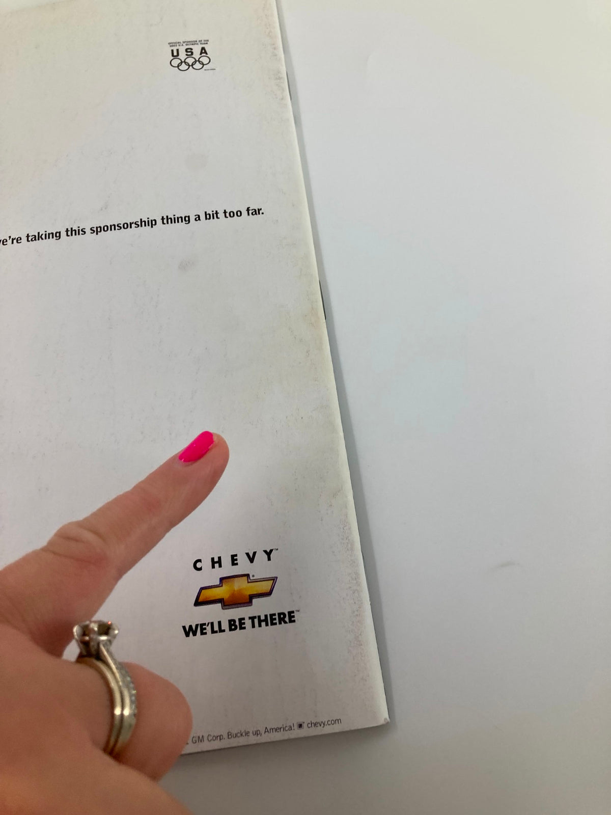 Close-up of the back cover of Sports Illustrated Magazine August 18, 2002, showing a hand pointing at the Chevrolet ad with the slogan, 'We'll Be There'.