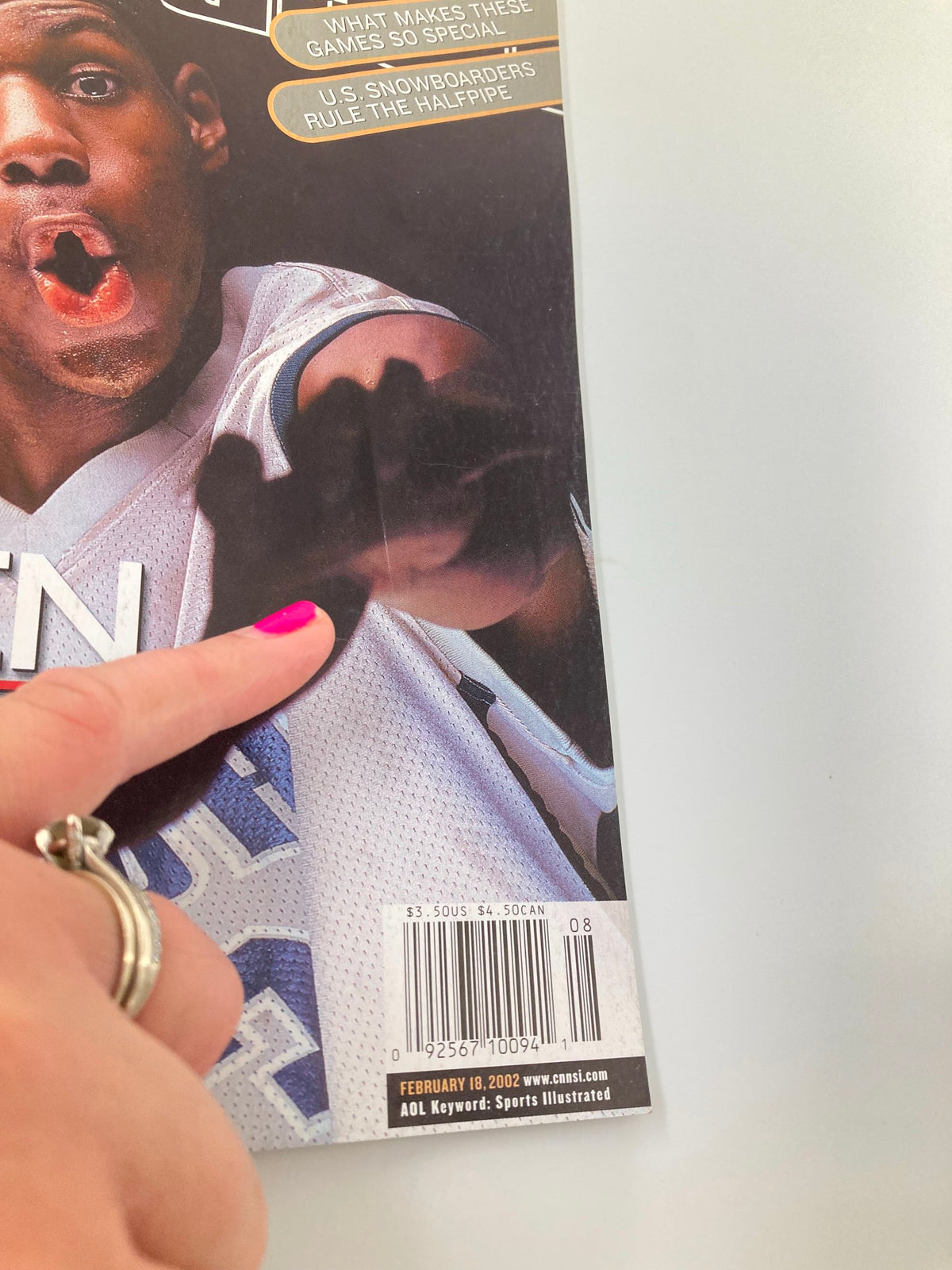 Close-up view of the Sports Illustrated Magazine August 18 2002 featuring high school LeBron James, capturing a moment of excitement with LeBron's hand extending towards the viewer, showcasing the magazine's interactive cover design.