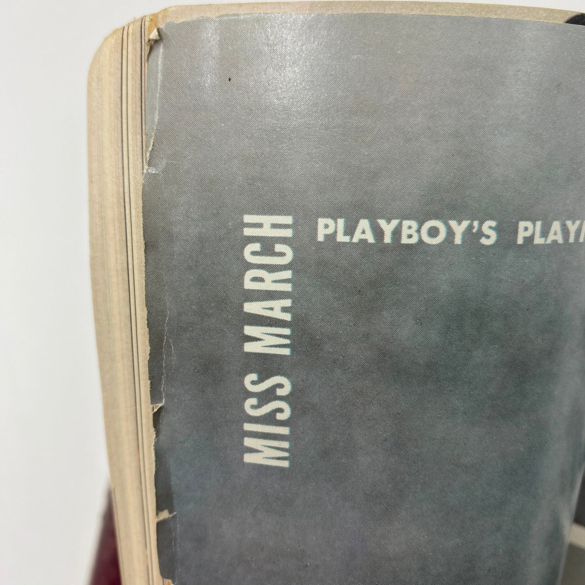 Detailed view of the spine of a VTG Playboy Magazine from March 1972, showcasing the edition's title 'Miss March' and its vintage aesthetic.