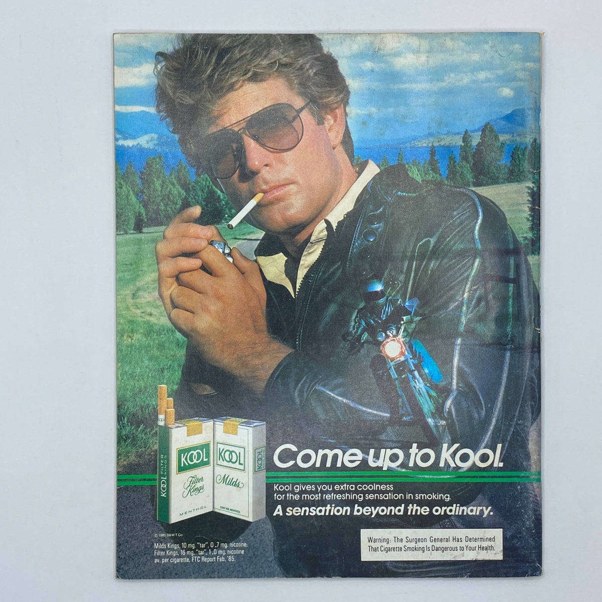 Vintage advertisement for Kool cigarettes featuring a man in sunglasses, highlighting the slogan 'Come up to Kool' from the May 1985 issue of Omni Magazine.