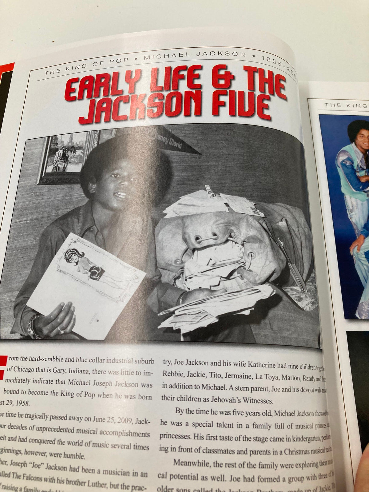 A young Michael Jackson with drawings, illustrating his childhood and early connection to performance in the Michael Jackson 1958-2009 Collector's Photo Gallery #07.
