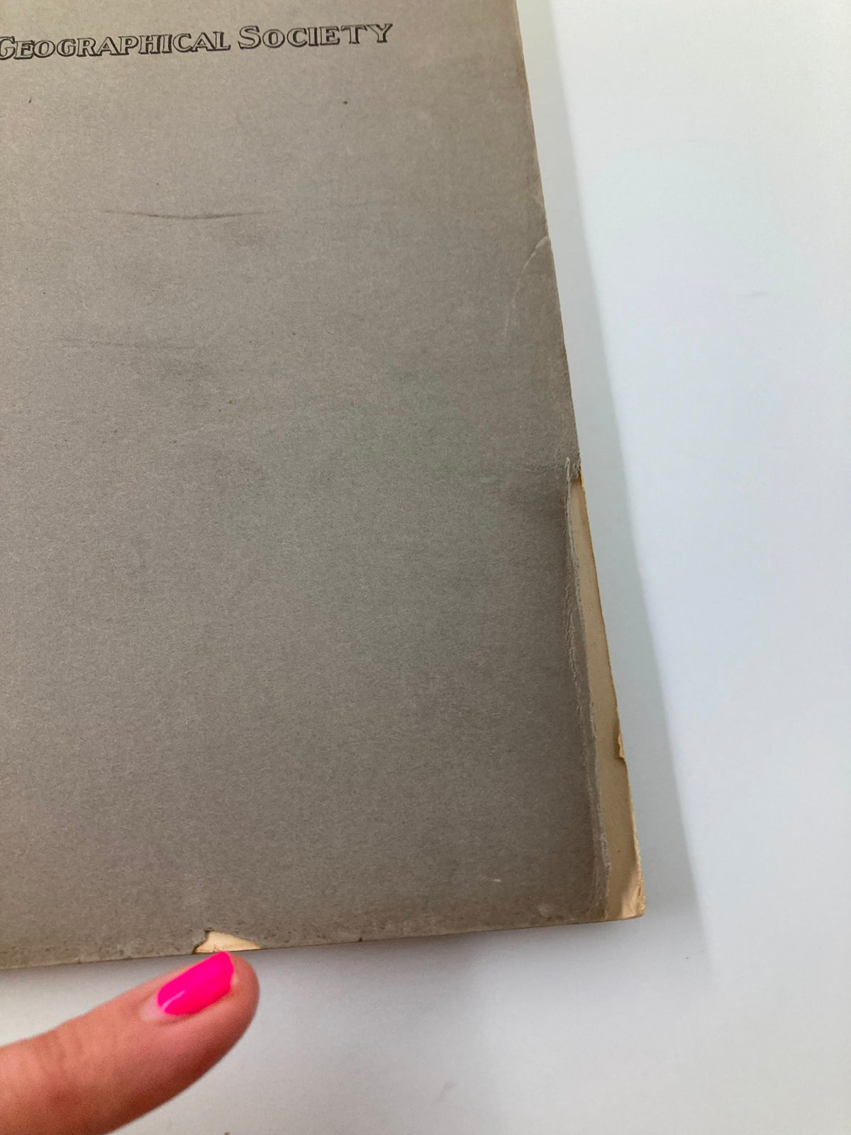 Side view of The Geographical Review by The American Geographical Society of New York, showing wear on the cover from its age.
