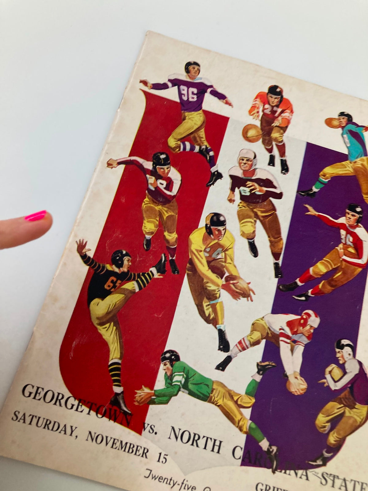 Close-up view of the November 15 1941 College Football Georgetown vs North Carolina State Program cover highlighting dynamic player illustrations.