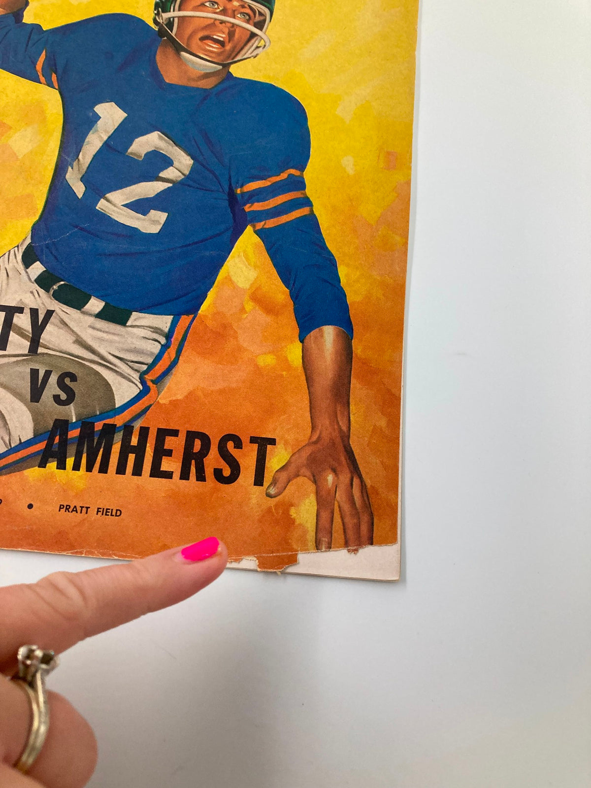 Close-up of the November 5, 1959 Trinity vs Amherst High School Football program showing minor wear and tear on the edge.