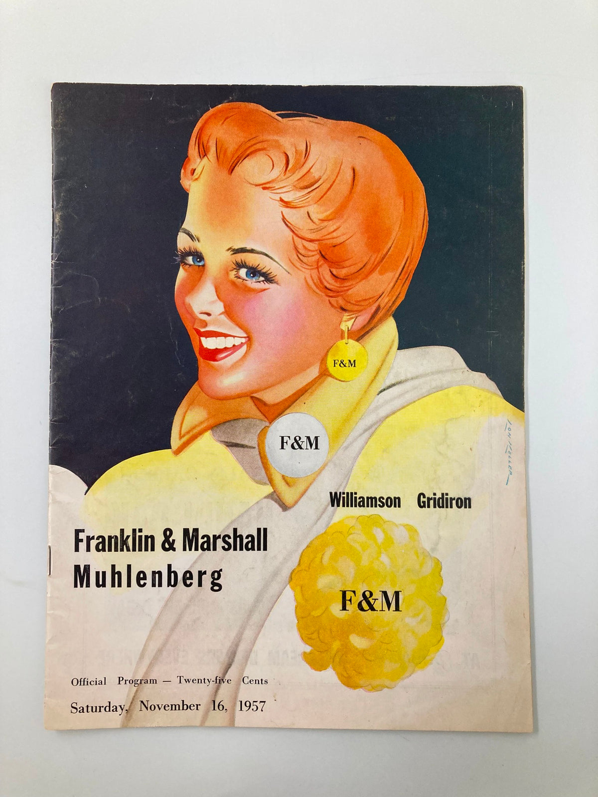 Cover of the November 16 1957 Football Franklin & Marshal Muhlenberg Official Program featuring a colorful illustration of a smiling woman with orange hair, showcasing the event details.