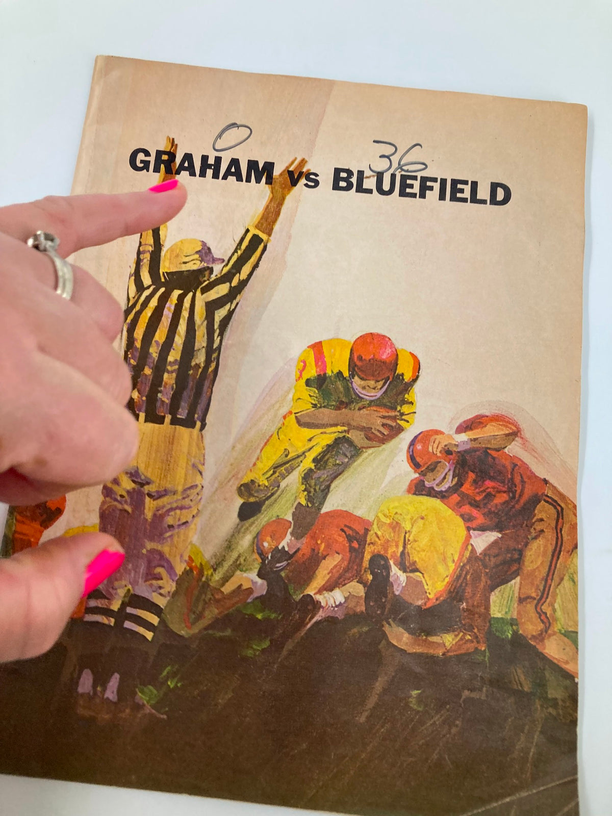 Close-up of the cover of the 1949 High School Football Graham G-Men vs Bluefield Beavers Official Program with a finger pointing at the score.